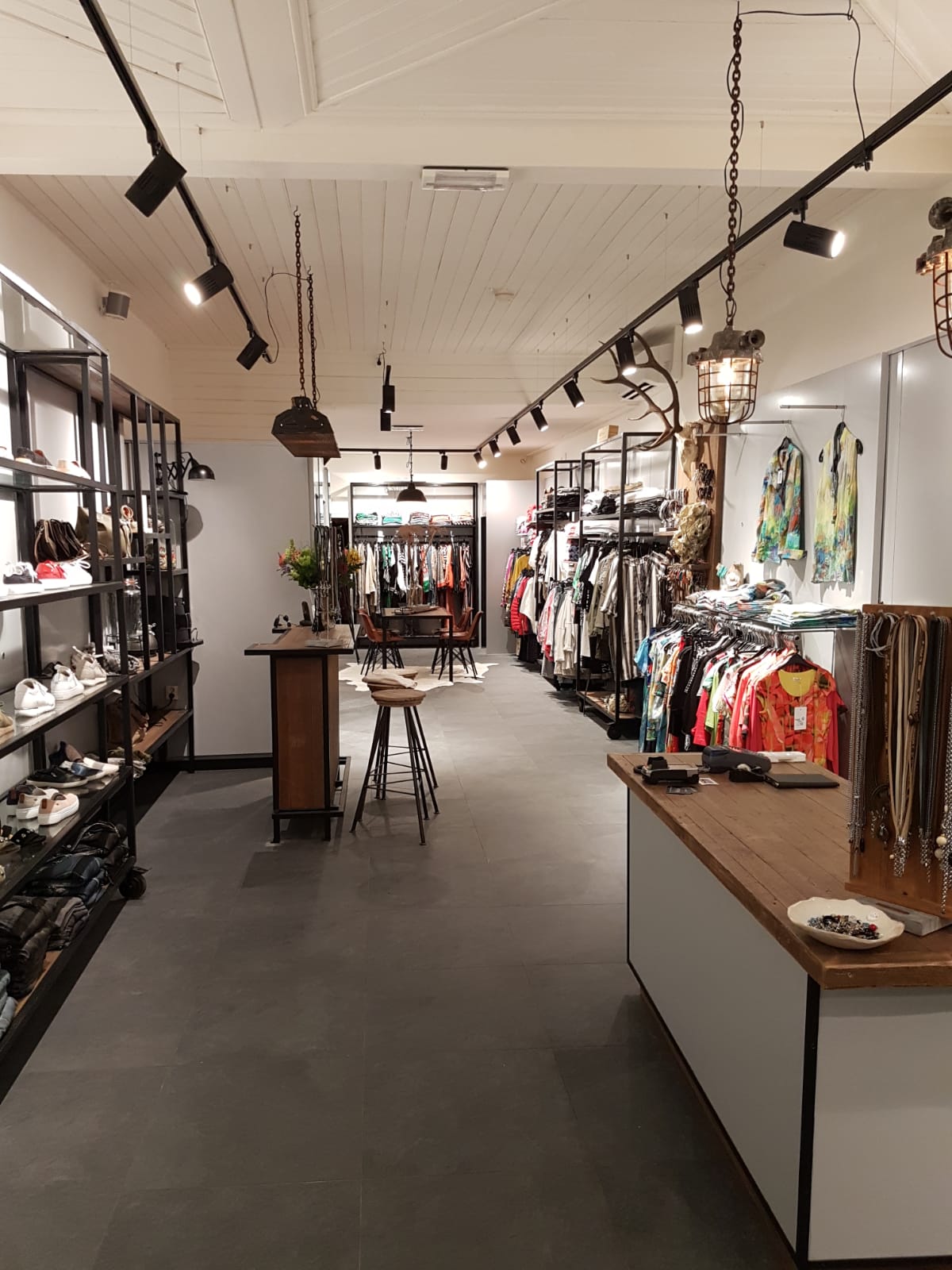 Railverlichting met spots en industriële hanglampen in een winkel